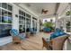 Comfortable covered patio with stylish wicker seating, ceiling fan, and views of the surrounding landscape at 5 Riverwalk Dr # 604, New Smyrna Beach, FL 32169