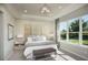 Cozy main bedroom featuring a tray ceiling, a large window, and neutral-toned walls at 5271 Quillback Ln, St Cloud, FL 34771