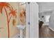 Stylish half-bathroom featuring unique mirror and sink and decorative palm tree art at 6218 Forsythe Loop, Sanford, FL 32771