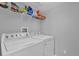 Functional laundry room with washer, dryer, and overhead storage shelf at 6218 Forsythe Loop, Sanford, FL 32771