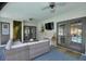 Inviting covered patio with comfortable seating, a mounted TV, and access to the pool area at 731 Rosemere Cir, Orlando, FL 32835