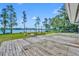 Expansive deck overlooking a scenic lake, surrounded by lush trees and open lawn at 7420 Lake Willis Dr, Orlando, FL 32821