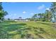 Sprawling backyard of property showcasing lawn, white house, and plenty of space for outdoor activities at 7420 Lake Willis Dr, Orlando, FL 32821