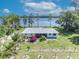 Charming single-story home featuring a picturesque lake view and lush landscaping at 7420 Lake Willis Dr, Orlando, FL 32821