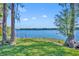 Scenic lake view from a wooded backyard, with a private pier extending into the calm water at 7420 Lake Willis Dr, Orlando, FL 32821