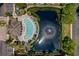 Aerial view featuring a pool, water feature, mature trees, and community buildings at 10154 Regent Square Dr # 201, Orlando, FL 32825