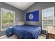 Cozy bedroom with two windows and a Chelsea Football Club flag at 10154 Regent Square Dr # 201, Orlando, FL 32825