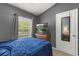 Cozy bedroom featuring a window with natural light and a wall-mounted television at 10154 Regent Square Dr # 201, Orlando, FL 32825