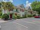 Inviting townhouse exterior with a palm tree and ample parking at 10154 Regent Square Dr # 201, Orlando, FL 32825