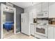 Kitchen with white appliances next to doorway to bedroom at 10154 Regent Square Dr # 201, Orlando, FL 32825
