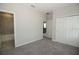 Neutral bedroom featuring plush carpet, ensuite bathroom, and double door closet at 1030 Teal Creek Dr, St Cloud, FL 34771