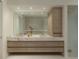 Elegant bathroom features a dual sink vanity with marble countertop and modern wood drawers at 10339 Kensington Shore Dr # J-202, Orlando, FL 32827