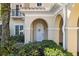 Charming home entrance with an arched doorway, enhanced by lush landscaping, and a tranquil setting at 10339 Kensington Shore Dr # J-202, Orlando, FL 32827