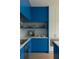 Contemporary kitchen with blue cabinets, white countertops, open shelving, and modern appliances at 10339 Kensington Shore Dr # J-202, Orlando, FL 32827