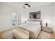 Bright main bedroom boasts modern lighting, neutral tones, and balcony access through french doors at 10339 Kensington Shore Dr # J-202, Orlando, FL 32827