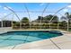 Enclosed pool and spa area featuring tropical landscaping and bright sunlight at 1135 Marni Ridge Ct, Kissimmee, FL 34747