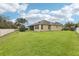 Expansive backyard featuring lush green grass and the home's rear exterior, enclosed by a white fence at 11725 Verrazano Dr, Orlando, FL 32836