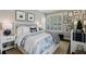 Cozy bedroom with natural light, plantation shutters, a blue comforter, and curated wall decor at 11725 Verrazano Dr, Orlando, FL 32836