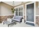 Inviting front porch with stone accents, comfortable seating, and stylish decor at 11725 Verrazano Dr, Orlando, FL 32836