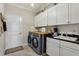 Well-organized laundry room with modern washer and dryer, storage cabinets, and sink with countertop at 11725 Verrazano Dr, Orlando, FL 32836
