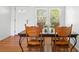 Bright dining room with hardwood floors, large window, and a charming wood dining set with decorative chairs at 1207 Cole Rd, Orlando, FL 32803