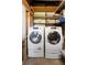 Efficient laundry room with modern washer and dryer units, complemented by convenient shelving and storage space at 1207 Cole Rd, Orlando, FL 32803