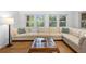 Comfortable living room with hardwood floors, a large sectional sofa, and natural light from the windows at 1207 Cole Rd, Orlando, FL 32803