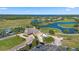 Aerial view of a golf course community with a clubhouse, lush green fairways, and a scenic water feature at 13090 Bromborough Dr, Orlando, FL 32832