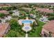 Scenic aerial view of a community pool and spa with surrounding landscaping, palm trees, and homes at 13090 Bromborough Dr, Orlando, FL 32832