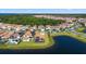 Aerial view of a lakeside community with homes featuring tile roofs and access to a tranquil lake at 13090 Bromborough Dr, Orlando, FL 32832