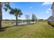 Lush green backyard featuring a tranquil pond surrounded by mature trees and landscaping at 13090 Bromborough Dr, Orlando, FL 32832