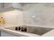 Modern flat cooktop with white backsplash and light gray cabinets in the kitchen at 13090 Bromborough Dr, Orlando, FL 32832