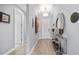 Elegant hallway with a chandelier, decor, and light wood-look flooring at 13090 Bromborough Dr, Orlando, FL 32832
