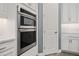 Modern kitchen with stainless steel microwave and oven, white cabinets, and recessed lights at 13090 Bromborough Dr, Orlando, FL 32832