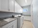 Well-equipped laundry room with granite countertops, modern washer/dryer, and plenty of cabinet space at 13090 Bromborough Dr, Orlando, FL 32832