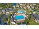 Aerial view of a community pool with sun loungers and umbrellas, surrounded by lush landscaping and homes at 13090 Bromborough Dr, Orlando, FL 32832