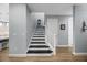 Stairway featuring black treads and white risers, accented by light grey walls at 13090 Bromborough Dr, Orlando, FL 32832