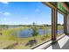 Serene window view of a lush pond surrounded by landscaping and a clear blue sky at 13090 Bromborough Dr, Orlando, FL 32832