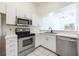 Modern kitchen with stainless steel appliances, white cabinets, and tile flooring at 133 Reserve Cir # 109, Oviedo, FL 32765