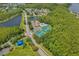 Aerial view of the community featuring tennis courts, pool, clubhouse, and surrounding lakes and lush landscaping at 14750 Hartford Run Dr, Orlando, FL 32828