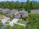 Expansive aerial view showcases a well-maintained home with a green lawn in a tree-filled residential area at 14750 Hartford Run Dr, Orlando, FL 32828