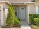 Close-up of the home's entrance, featuring a white front door, trimmed bushes, and a lantern at 14750 Hartford Run Dr, Orlando, FL 32828