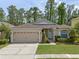Charming one-story home featuring a two-car garage, well-maintained lawn, and inviting front entrance at 14750 Hartford Run Dr, Orlando, FL 32828