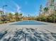 Well-maintained tennis court surrounded by palm trees and landscaping in a residential community at 14750 Hartford Run Dr, Orlando, FL 32828