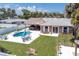 Aerial view of the in-ground pool, patio, outdoor kitchen, well maintained lawn and waterfront canal at 151 Sea Isle Cir, South Daytona, FL 32119