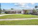 Traditional brick home with a spacious lawn, attached garage and well manicured shrubbery at 151 Sea Isle Cir, South Daytona, FL 32119