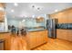 Open-concept kitchen and dining area with stainless steel appliances and light wood cabinets at 151 Sea Isle Cir, South Daytona, FL 32119