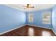 Bedroom features beautiful hardwood floors, two windows for natural light and a ceiling fan at 1516 Resolute St, Celebration, FL 34747