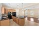 Open kitchen with granite countertops, island, stainless appliances, and wood cabinets at 1516 Resolute St, Celebration, FL 34747