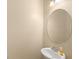 Neutral powder room with an oval mirror, pedestal sink and modern lighting fixture at 1516 Resolute St, Celebration, FL 34747